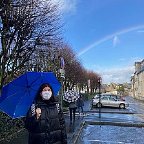 Lia mit Regenschirm und Regenbogen.