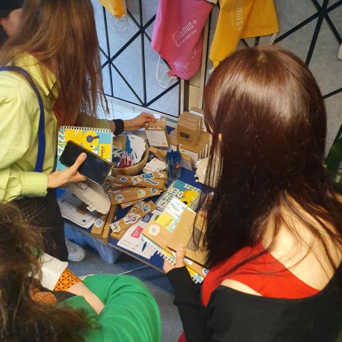 Drei Mädchen greifen bei den Erasmus+ und ESK Goodies zu