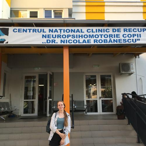 Ein Mädchen steht vor einer Klinik in Rumänien