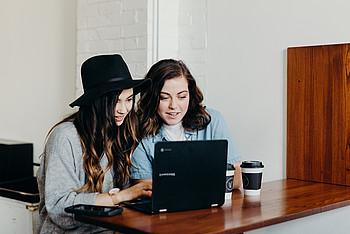 zwei junge Frauen vor Laptop (engl.)