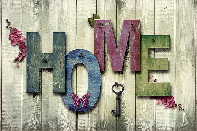 Wort "Home" aus buntem Holz auf einer Holzwand